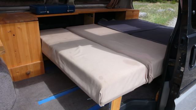 Seat-bed in lowered position. Note more cupboard space and lockbox at rear.