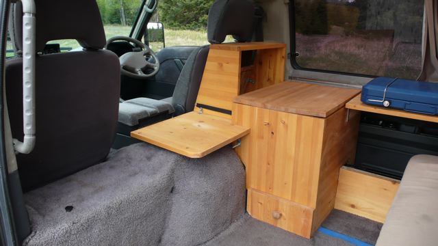 Camper unit showing cupboard space, counter, icebox, drawer, AC power outlet (hidden), propane stove